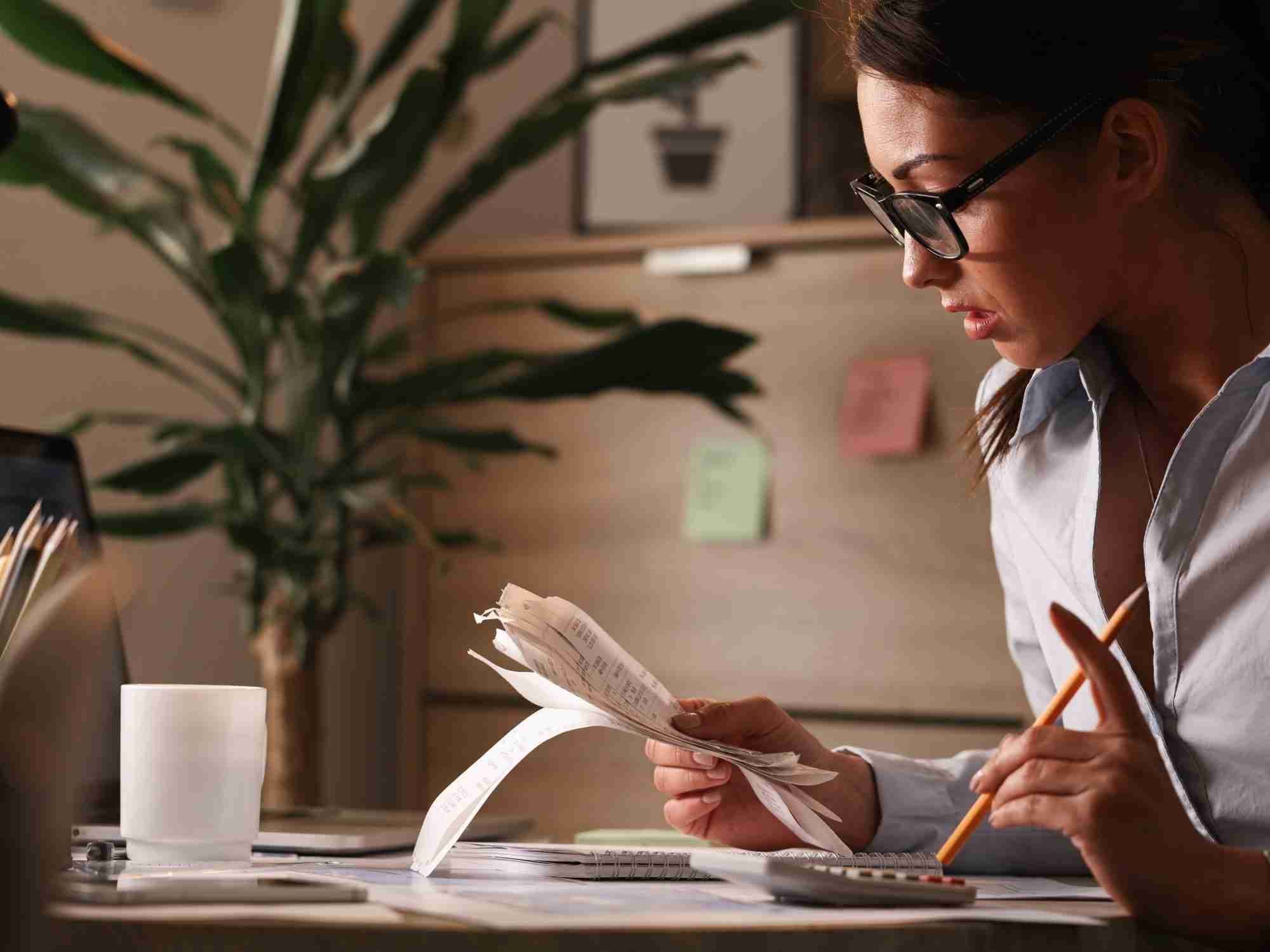female accountant calculating tax bills while working finances office edited scaled