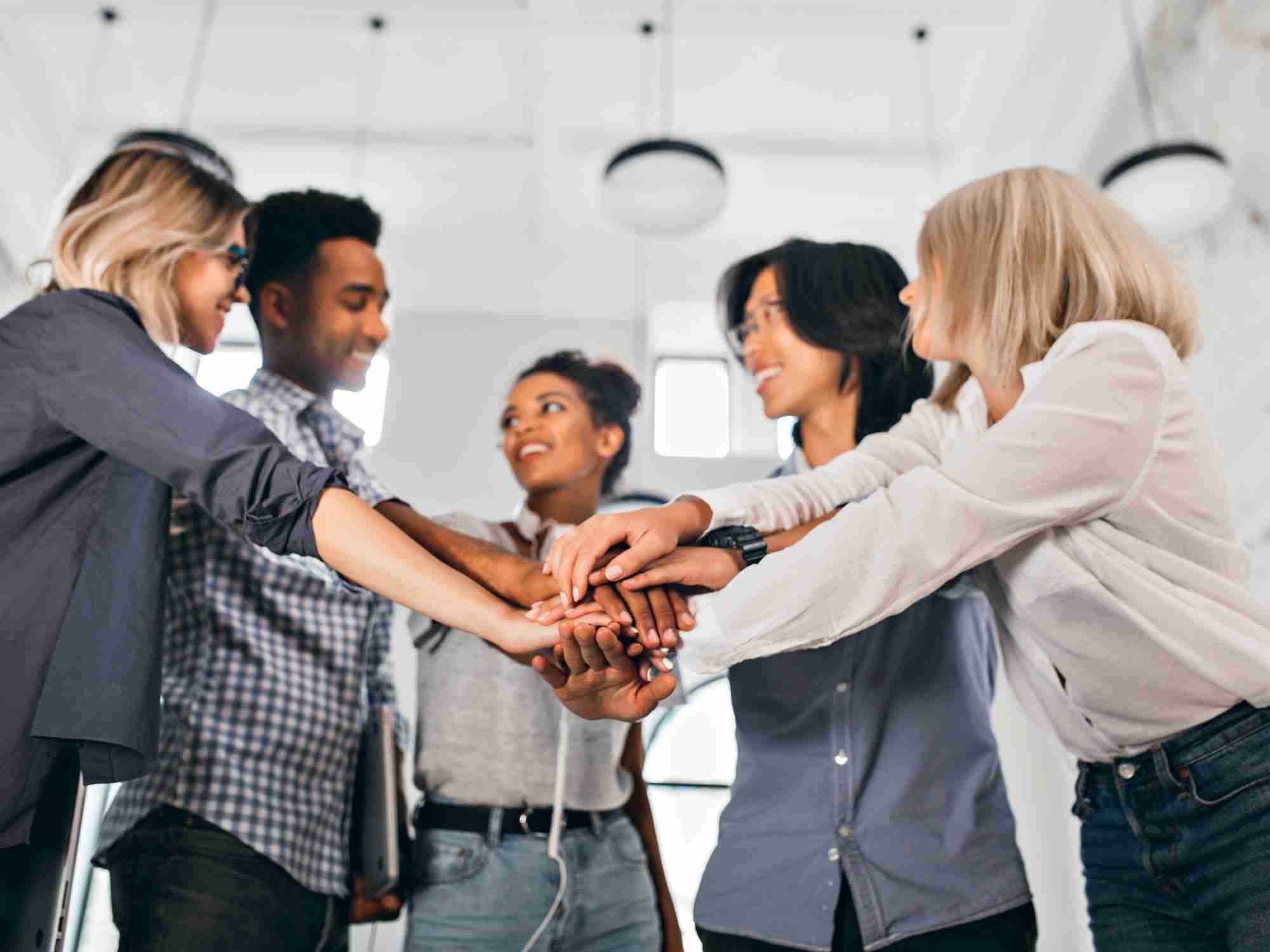 Incorporation vs employer of record (EOR) in China cheerful international students with happy face expression going work together science project indoor photo blonde woman trendy blouse holding hands with coworkers edited scaled